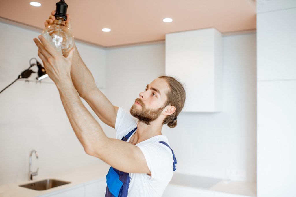 Handyman replacing lightbulb at home